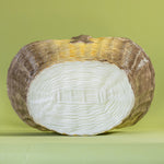 Large brown ceramic basket with woven texture and curved handle