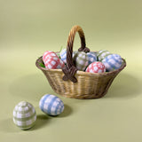 Large brown ceramic basket with woven texture and handle, styled with decorative pastel eggs
