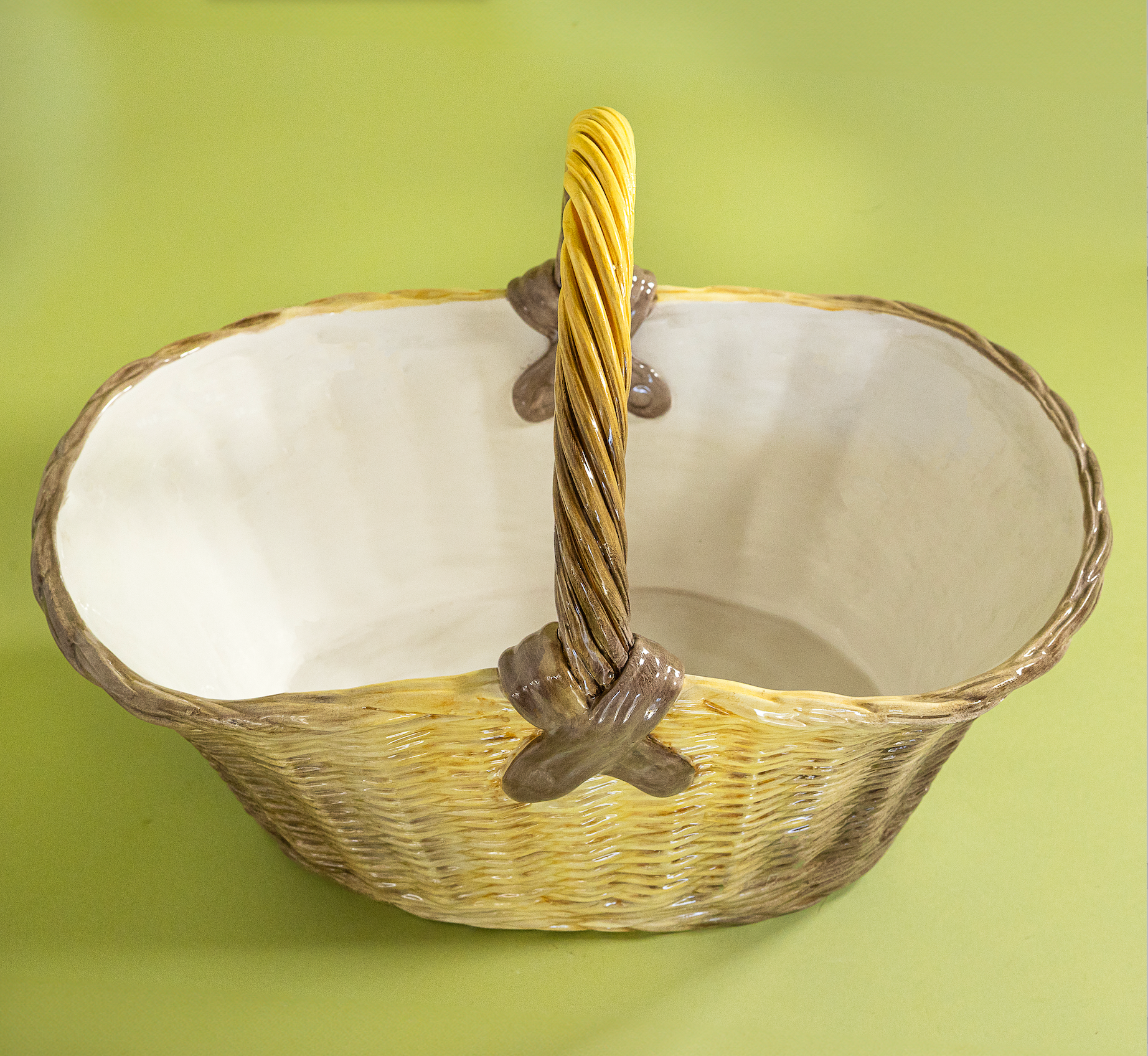 Large brown ceramic basket with woven texture and curved handle