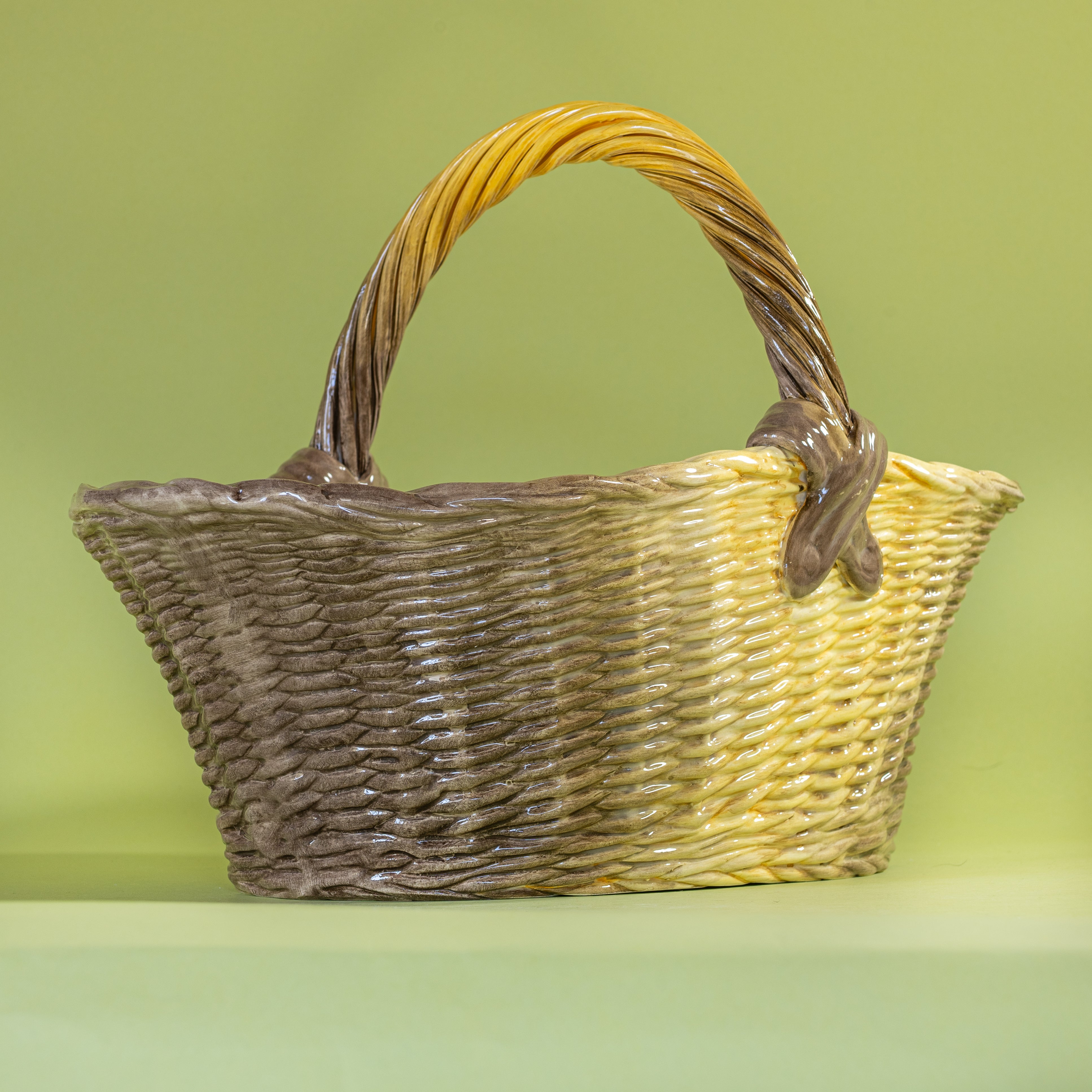 Large brown ceramic basket with woven texture and curved handle