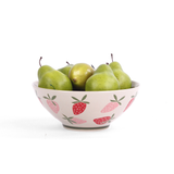 Large ceramic serving bowl with pink strawberry pattern, shown holding green pears