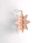 a large wooden star christmas ornaments painted in pink and white with distressed polka dot details