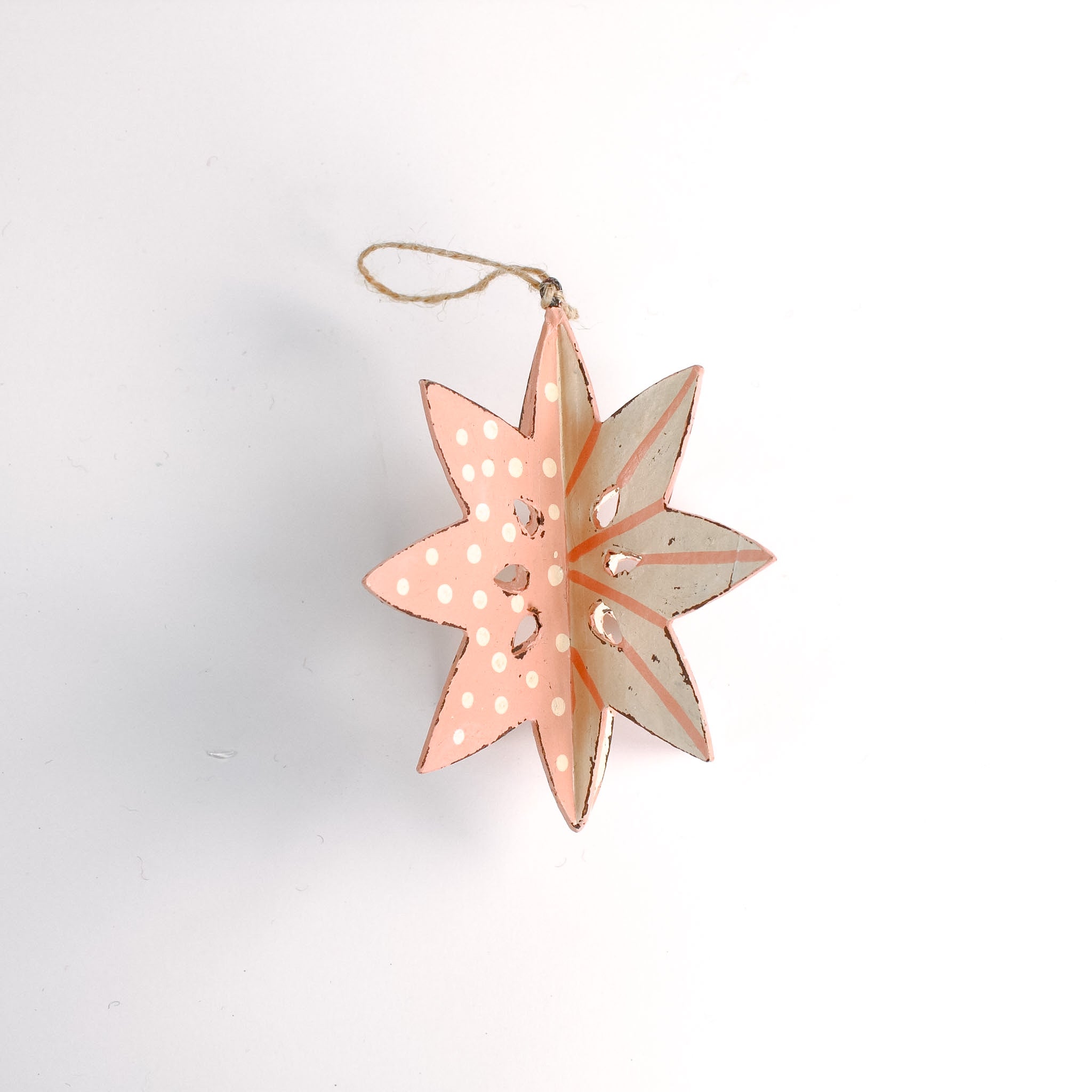 a large wooden star christmas ornaments painted in pink and white with distressed polka dot details