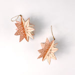 set of two large wooden star christmas ornaments painted in pink and white with distressed polka dot details