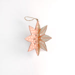 a large wooden star christmas ornaments painted in pink and white with distressed polka dot details