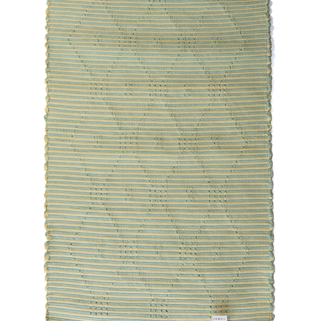 A madcap cottage yellow and green striped accent rug with a lattice motif across the front
