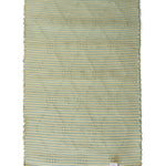 A madcap cottage yellow and green striped accent rug with a lattice motif across the front