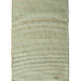A madcap cottage yellow and green striped accent rug with a lattice motif across the front