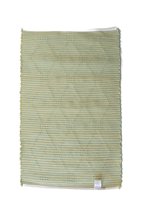 A madcap cottage yellow and green striped accent rug with a lattice motif across the front