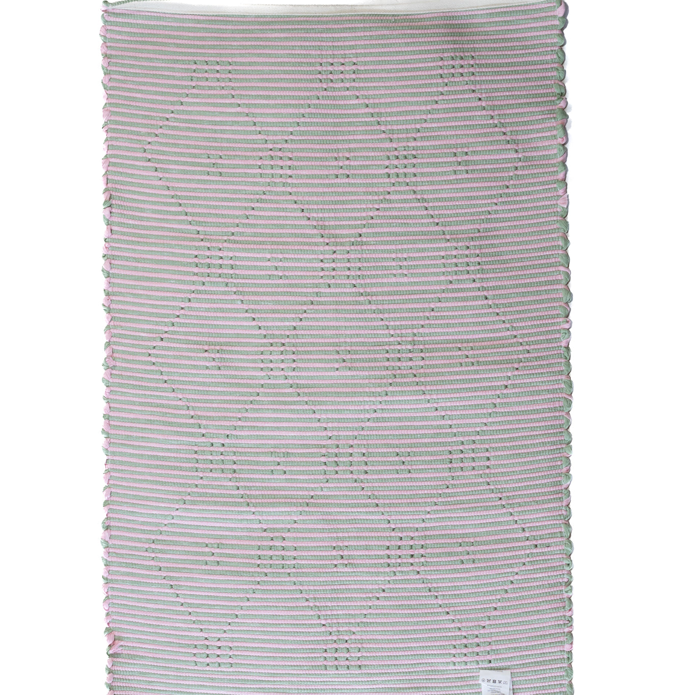 the plain reverse side of a pink and green accent rug from madcap cottage