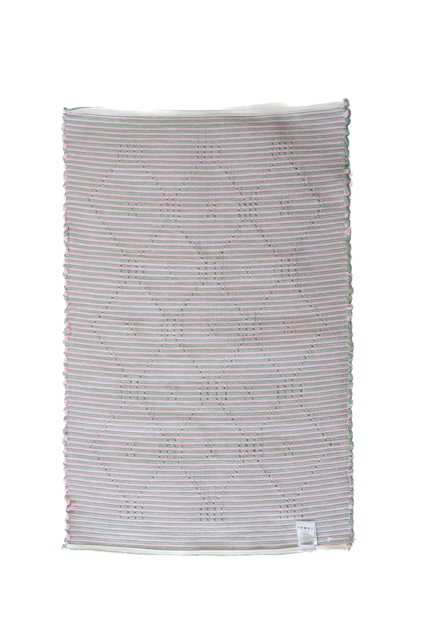 the plain reverse side of a pink and green accent rug from madcap cottage
