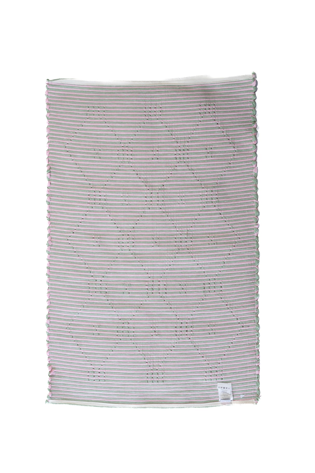 the plain reverse side of a pink and green accent rug from madcap cottage