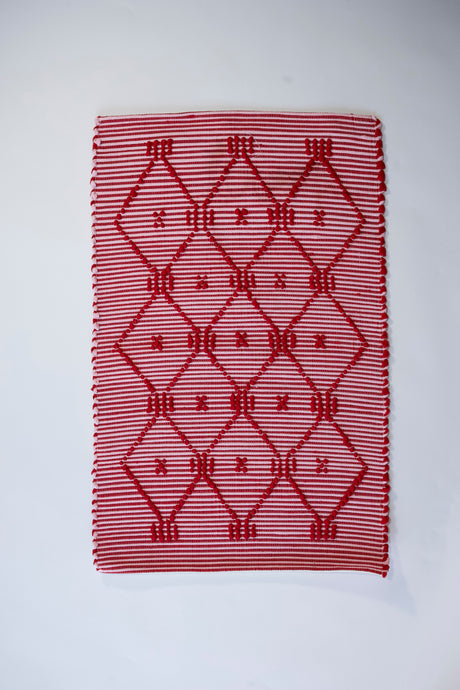 A madcap cottage white and red striped accent rug with a lattice motif across the front