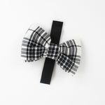 a MacLoecke Black/White Plaid Dog/Cat Bowties in Large showing the lace placed on a white surface
