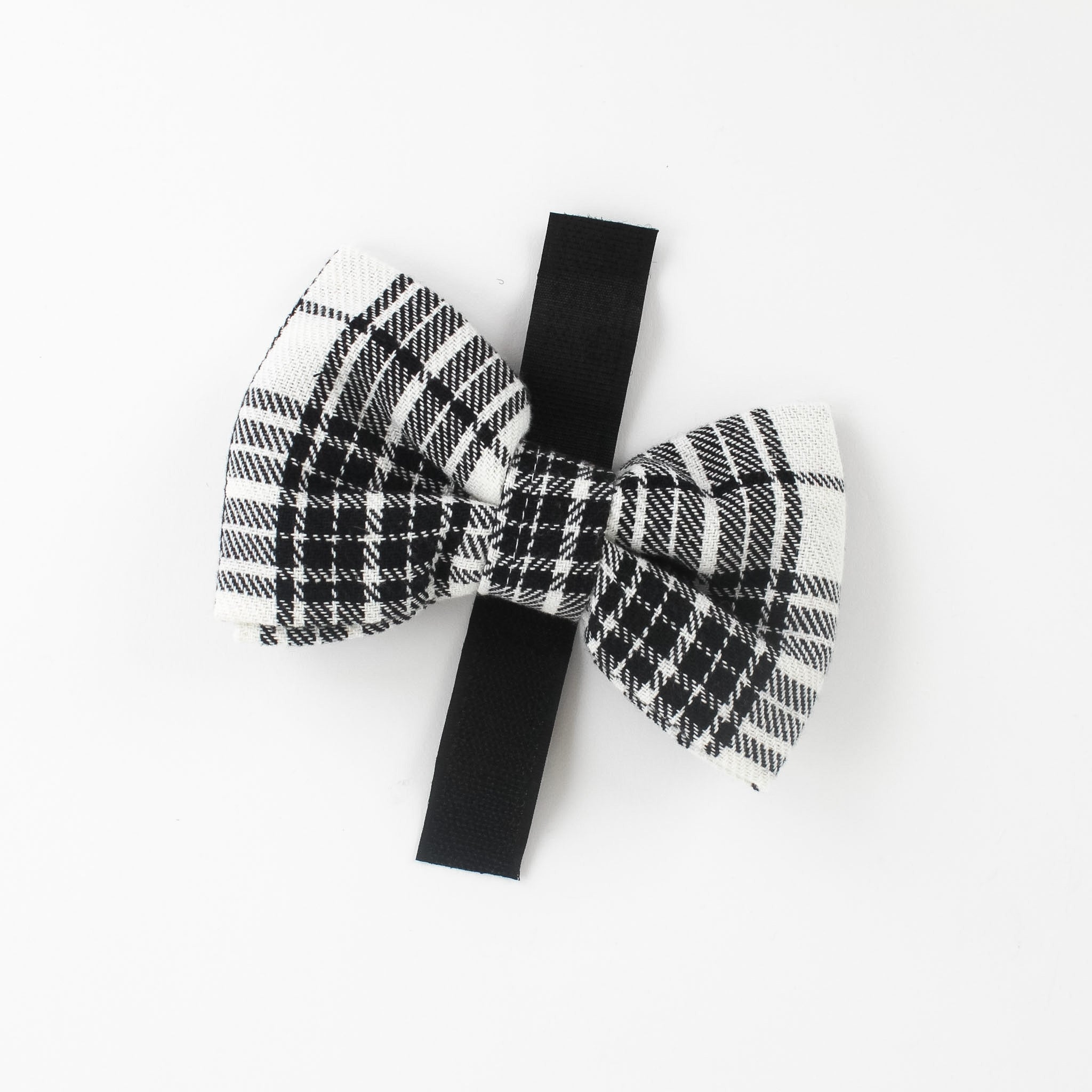 a MacLoecke Black/White Plaid Dog/Cat Bowties in Large showing the lace placed on a white surface