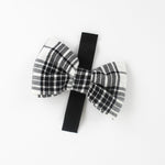 a MacLoecke Black/White Plaid Dog/Cat Bowties in Medium showing the lace placed on a white surface