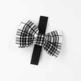 a MacLoecke Black/White Plaid Dog/Cat Bowties in Medium showing the lace placed on a white surface
