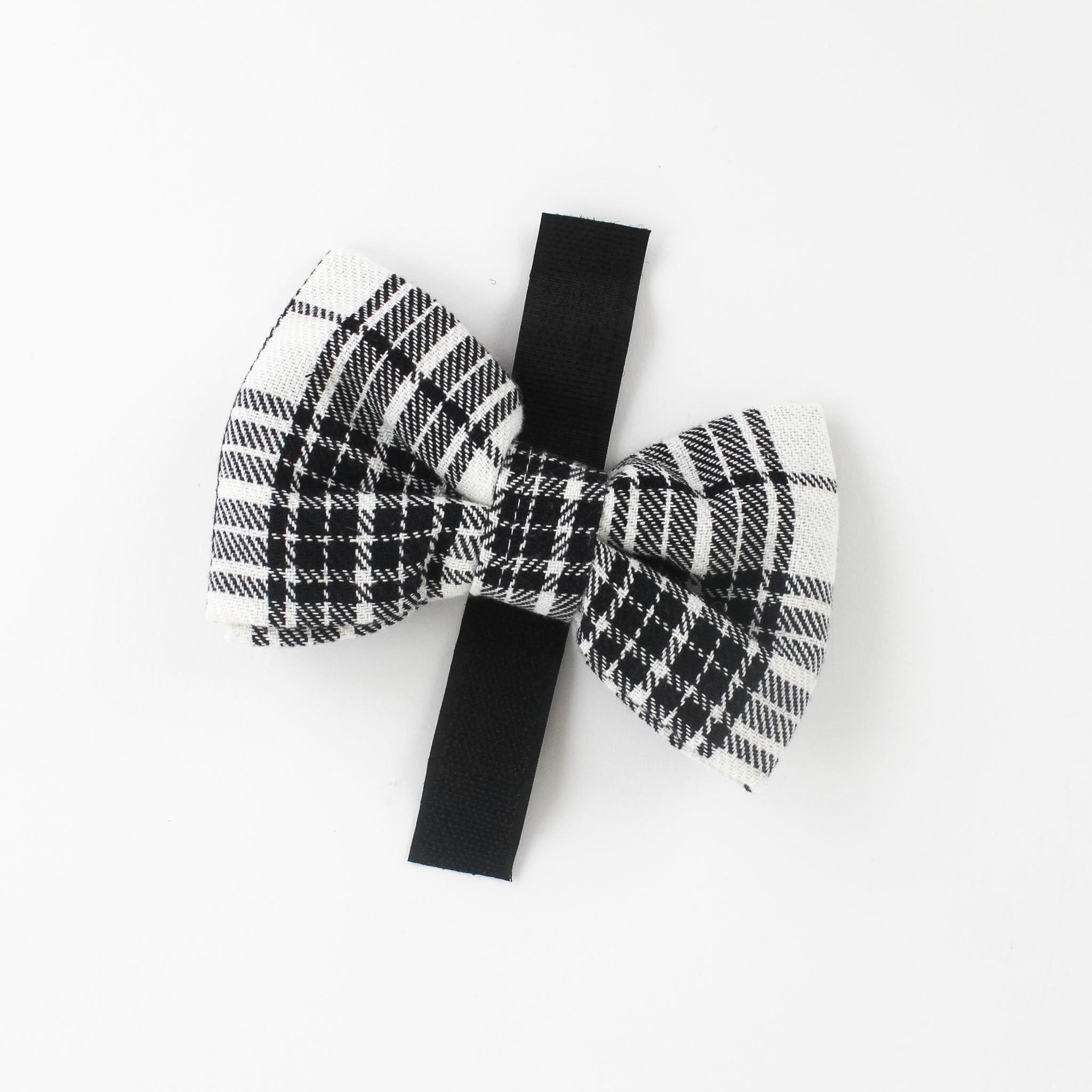 a MacLoecke Black/White Plaid Dog/Cat Bowties in Medium showing the lace placed on a white surface