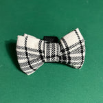 a MacLoecke Black/White Plaid Dog/Cat Bowties placed on a green surface