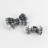 2 MacLoecke Black/White Plaid Dog/Cat Bowties in Medium and Large placed on a white surface