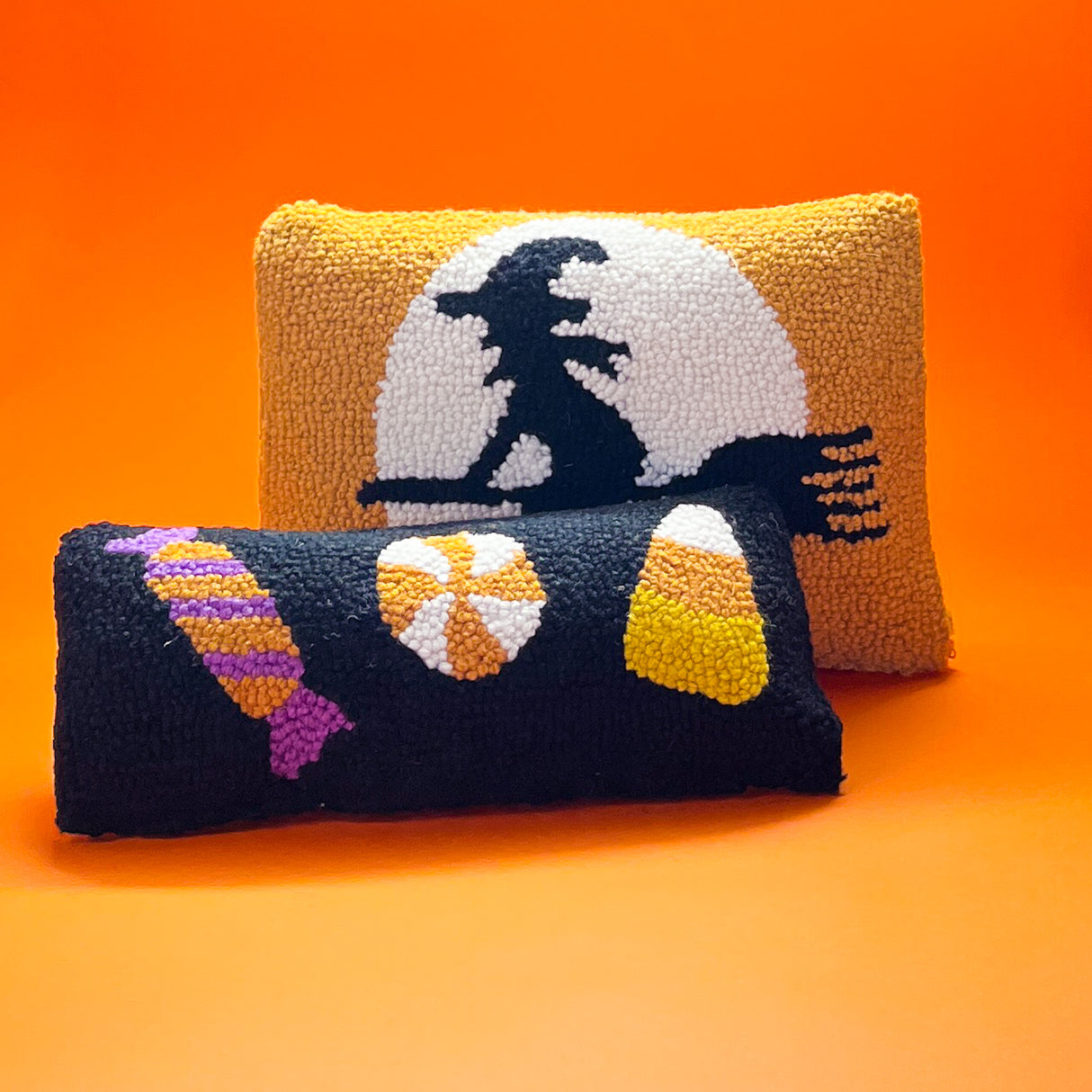 Madcap Cottage Black Halloween Throw pillow with three candy motifs image with another orange pillow with witch design