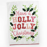 A Madcap Cottage Christmas tea towel with holly motifs and text that reads Have a Holly Jolly Christmas