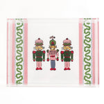 Three Nutcrackers on white background bordered with pink, blue, and green acrylic trays in large size.
