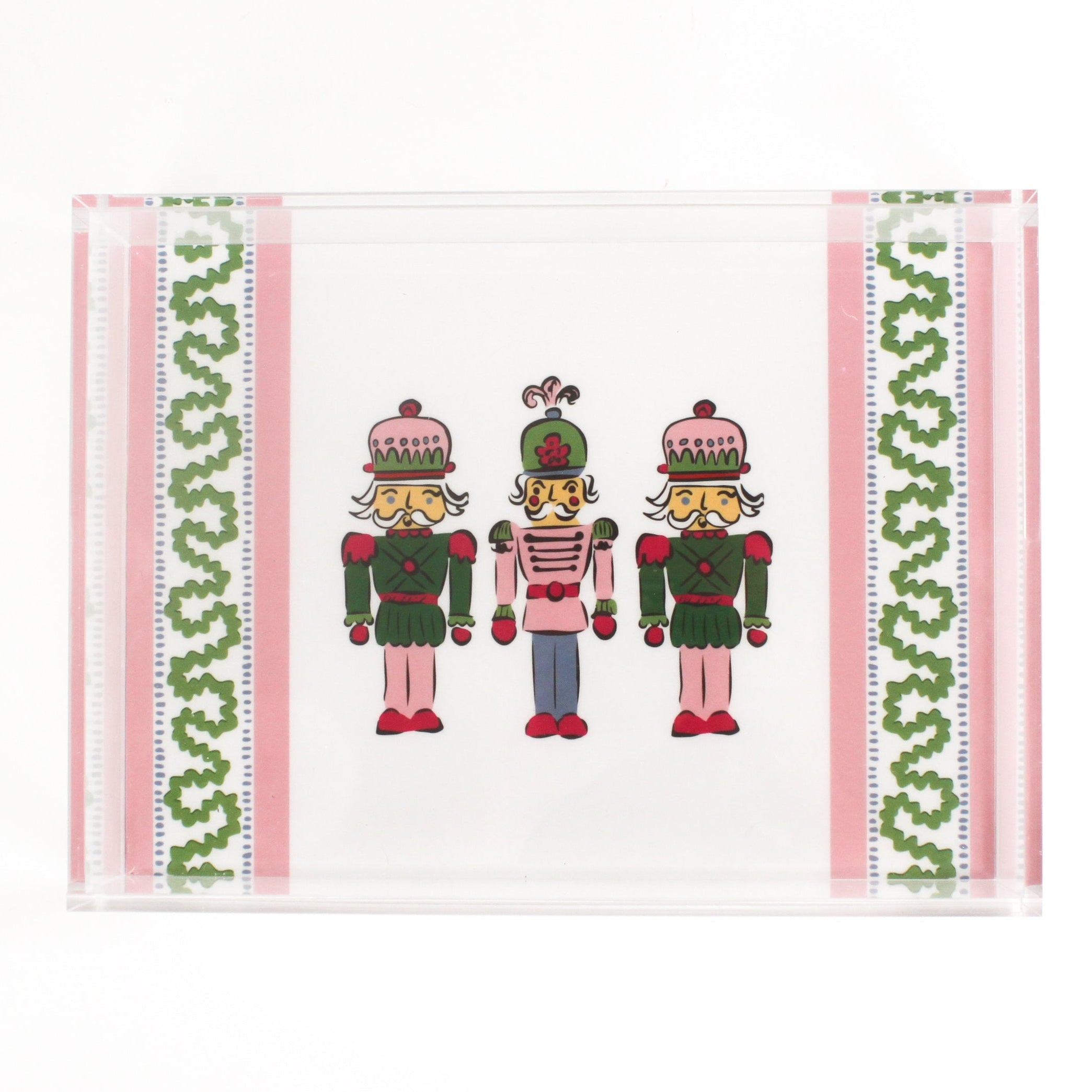 Three Nutcrackers on white background bordered with pink, blue, and green acrylic trays in large size.