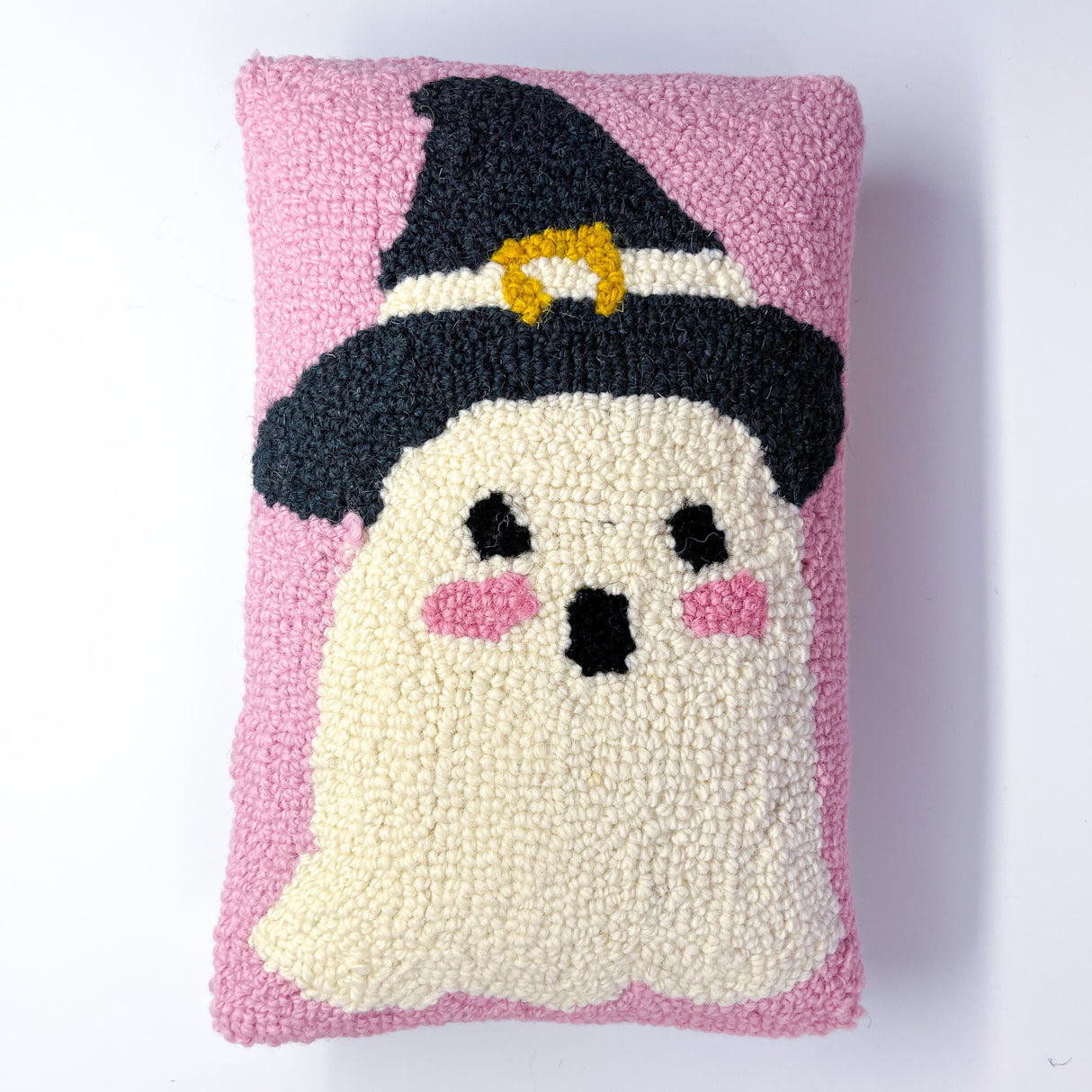 Madcap Cottage Pink throw pillow featuring a white ghost with pink cheeks wearing a black witch hat