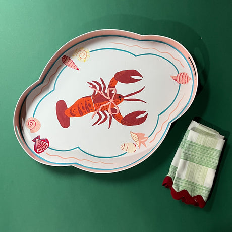 Large metal tole tray with a red rock lobster wearing a pink bow in the middle with shell and line border.