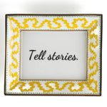 Madcap Cottage yellow and white porcelain trinket tray with a gold border and a saying that says Tell Stories.