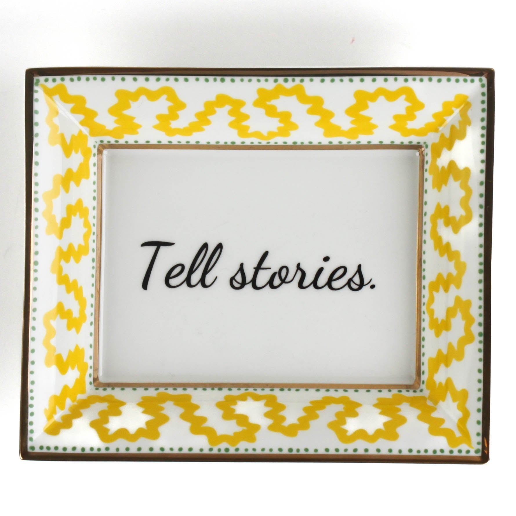 Madcap Cottage yellow and white porcelain trinket tray with a gold border and a saying that says Tell Stories.