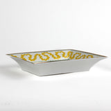 side view of the Madcap Cottage yellow and white porcelain trinket tray with a gold border and a saying that says Tell Stories.