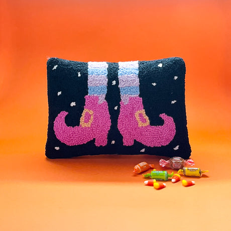 Madcap Cottage black throw pillow with pink witch shoes and striped stockings.