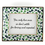 A rectangular porcelain trinket tray with a blue-and-green gingko-leaf patterned trim and gilt edging. The tray has text inside that reads 'You only live once, so don't settle for boring and expected.