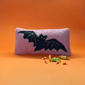 A pink wool halloween accent pillow with black bat design