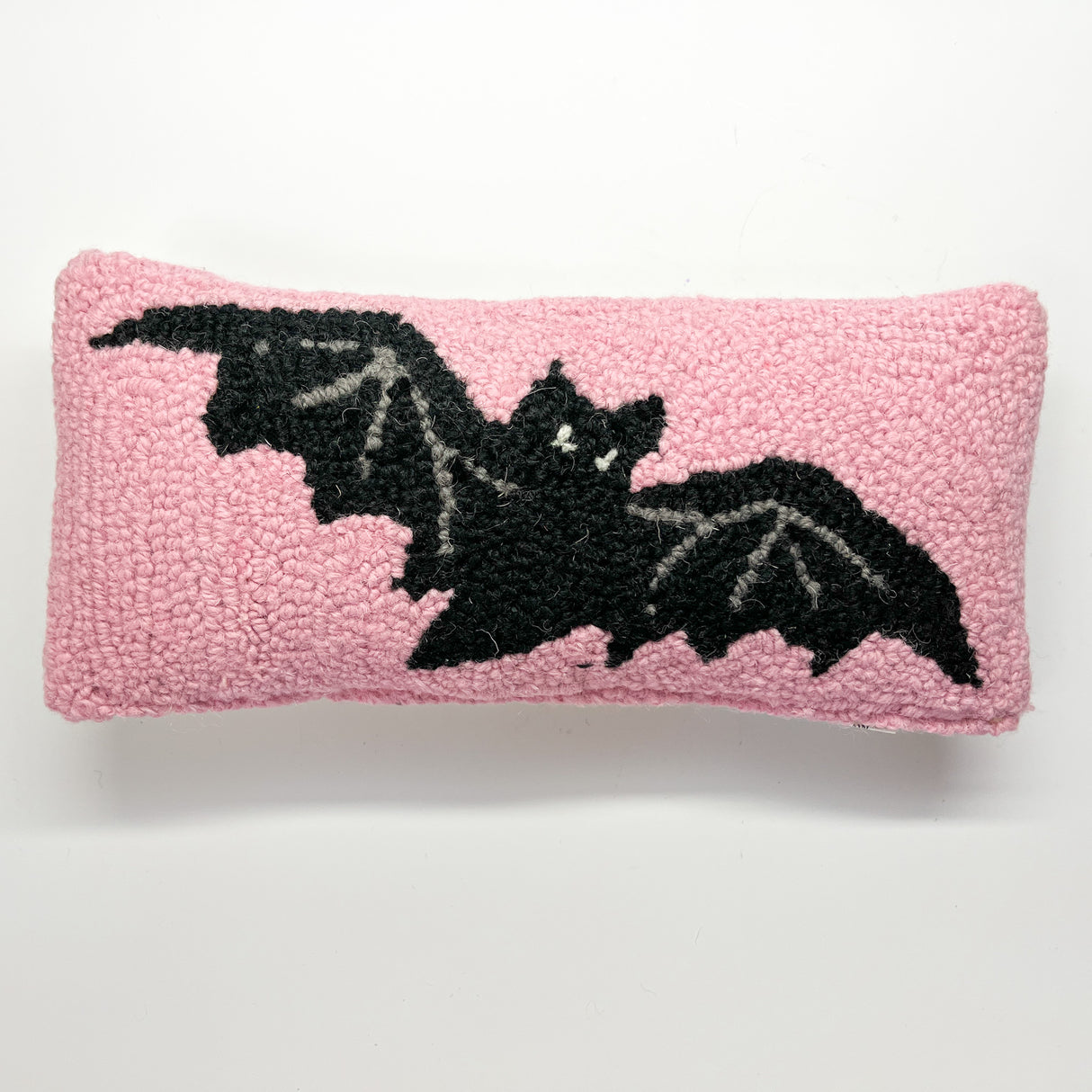 A pink wool lumbar halloween accent pillow with black bat design front