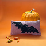 A pink wool lumbar halloween accent pillow with black bat design