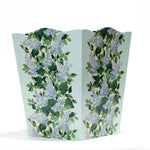 a blue floral wastepaper basket with a central repeating hydrangea pattern on each side. 