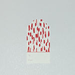 A red gift tag with a geometric pattern, displayed on a white background