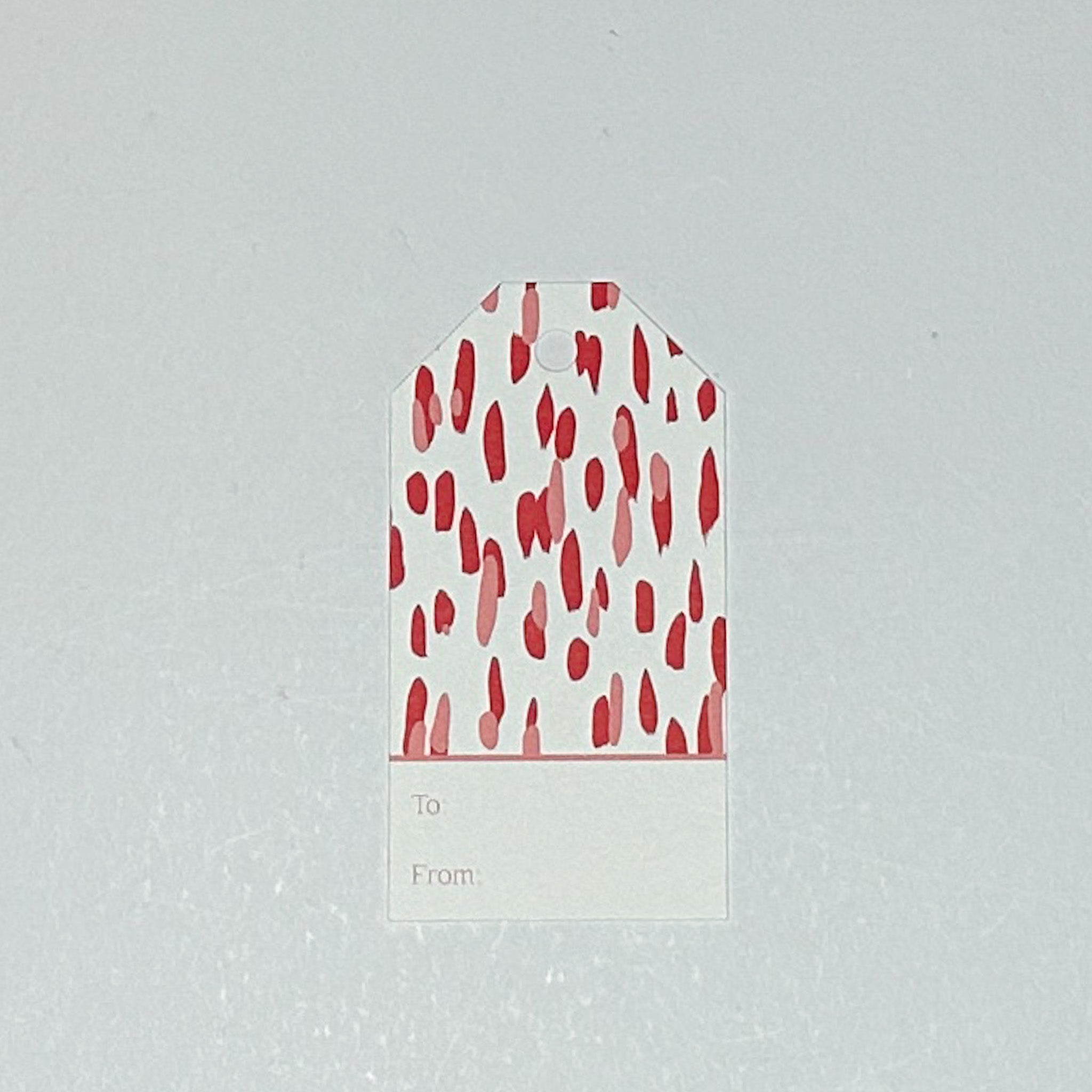 A red gift tag with a geometric pattern, displayed on a white background