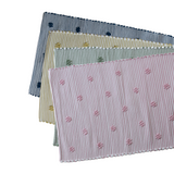 four cotton washable accent rugs from madcap cottage in navy blue, yellow, green and pink featuring a repeating daisy motif.