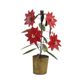 A large tole metal christmas candle holder in the shape of a poinsettia plant.