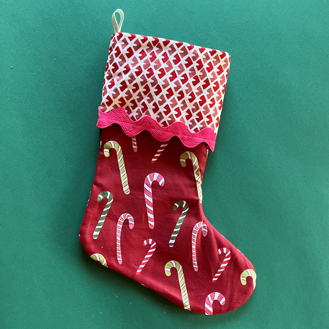 A red christmas stocking printed with candy canes