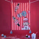 Four Nutcrackers on Pink and Red Stripe Background Tea Towel