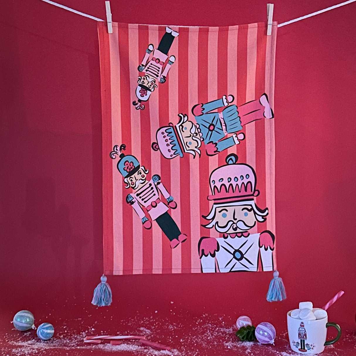 Four Nutcrackers on Pink and Red Stripe Background Tea Towel