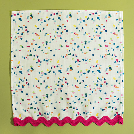 A confetti print fabric napkin from Madcap Cottage on a light green background.