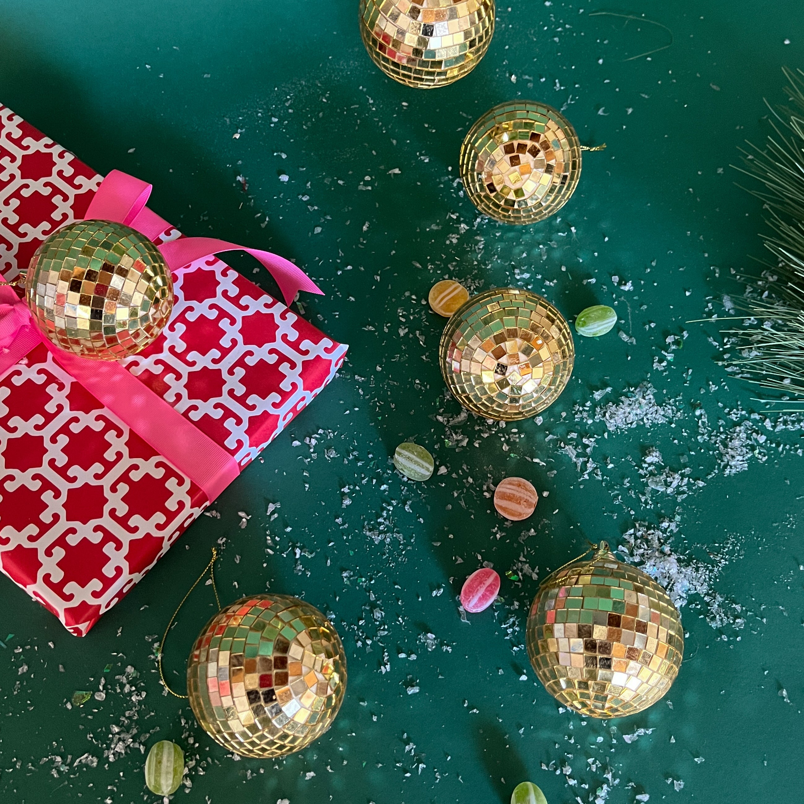 six mini gold disco ball ornaments on a green background