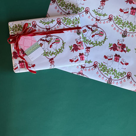 Cute Christmas wrapping paper decorated with white dancing mice holding ornaments and gift bags. 