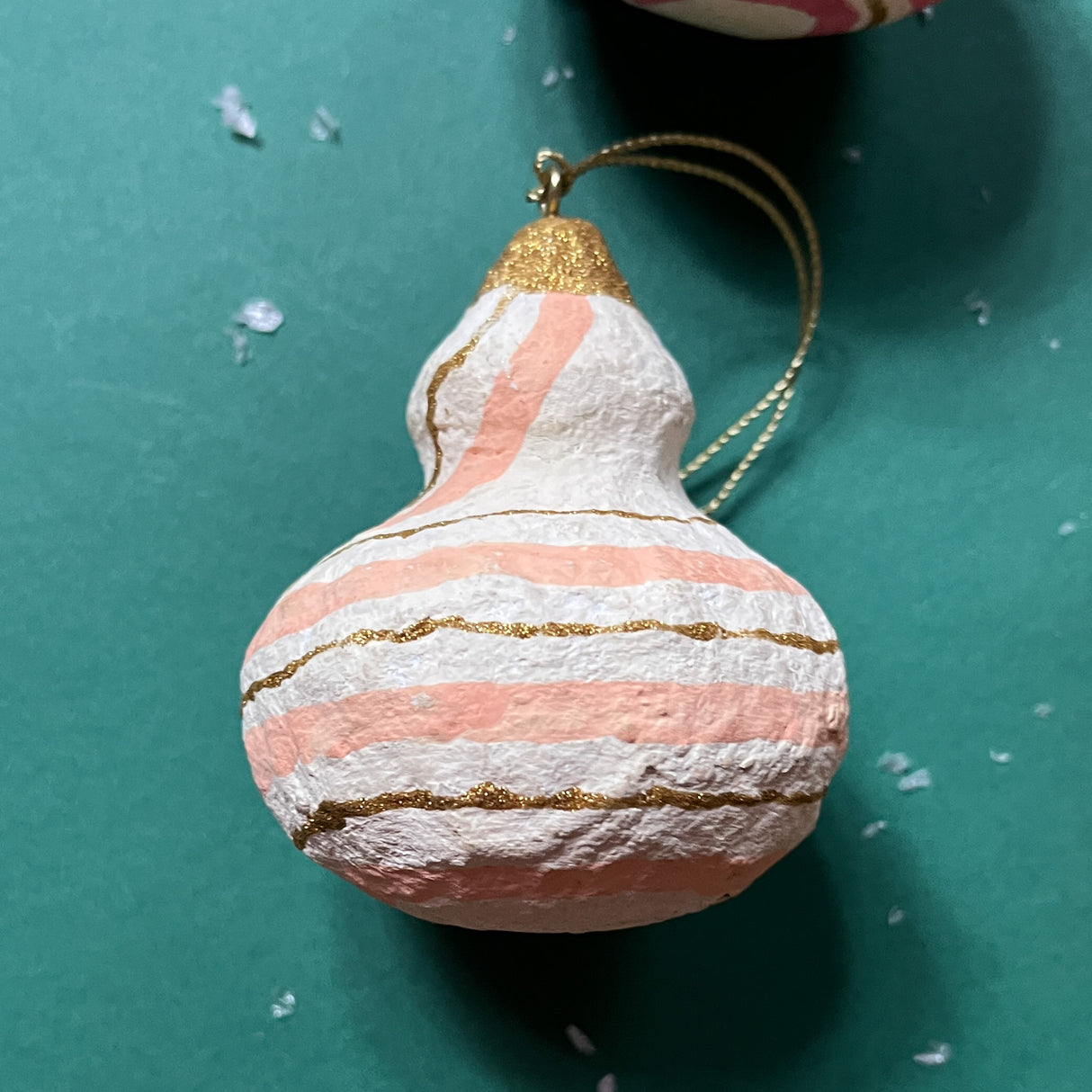 A madcap cottage papier mache ornament  with gold and orange stripes